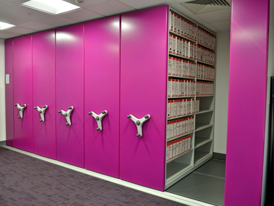High density mobile shelving with pink decorative end panels